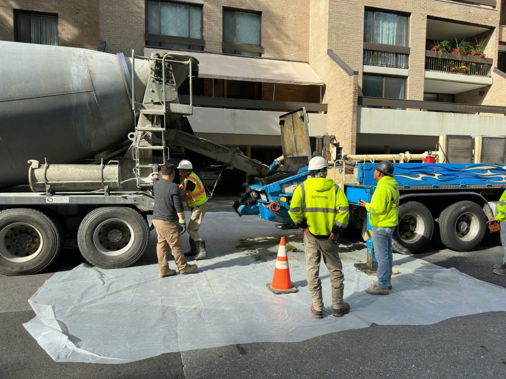a group of men standing next to a cement truck
